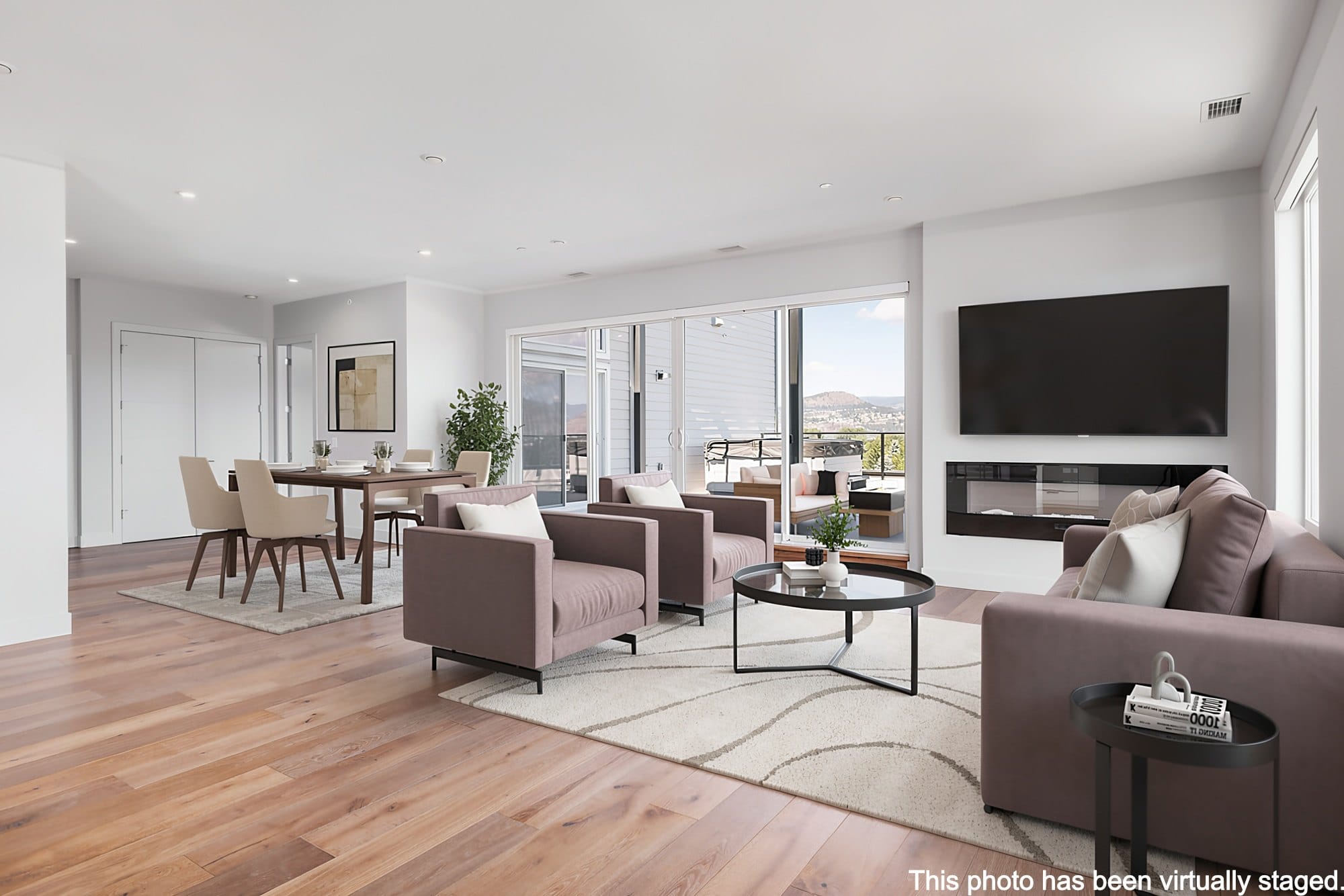 The penthouse living room at 701B, virtually staged, with the fireplace and the deck doors