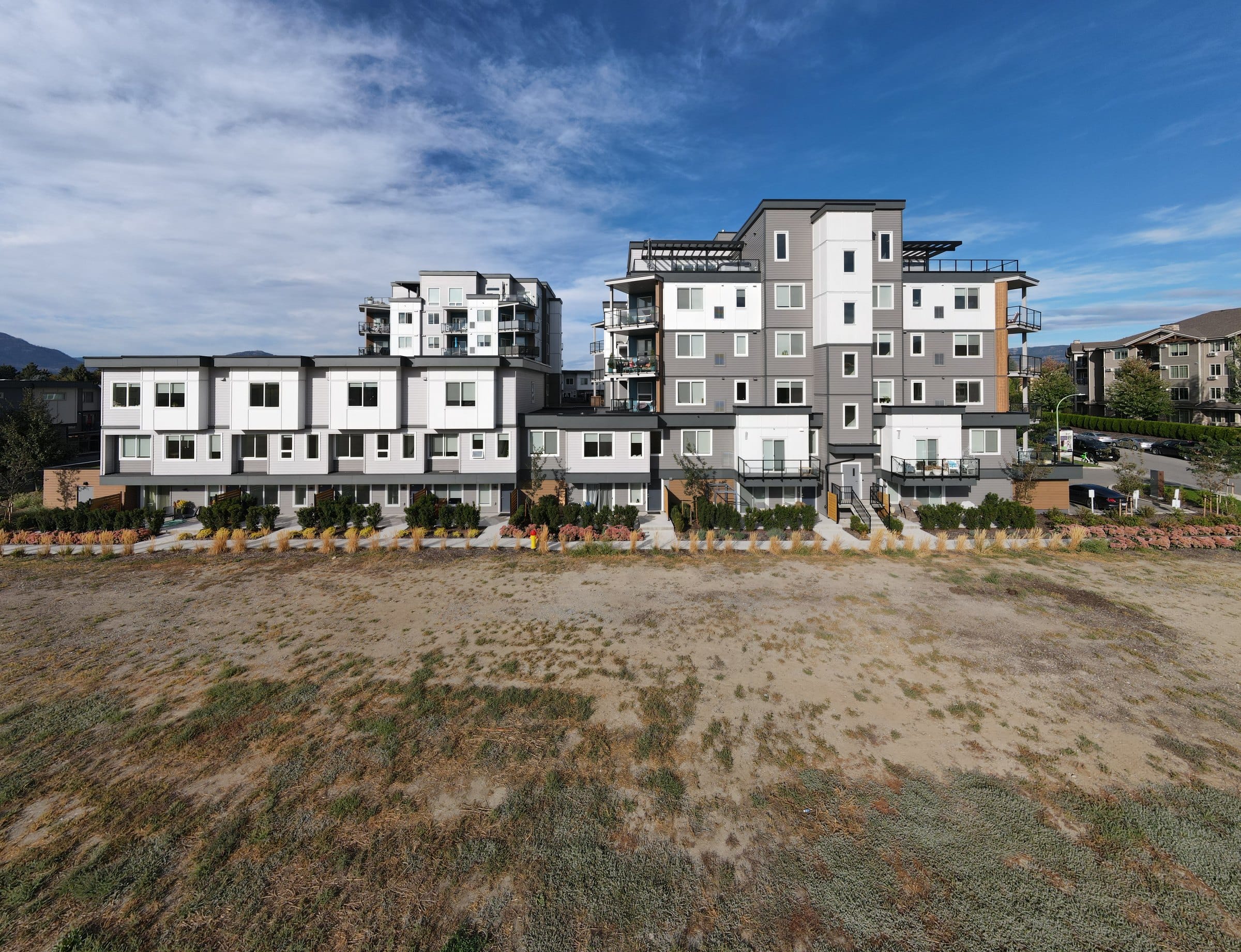 The two Green Square Vert buildings from the field in front, the townhome row along the ground