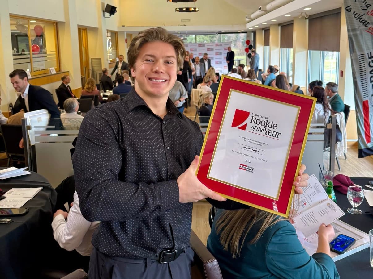 Karsen Koltun holding Royal LePage Rookie of the Year award