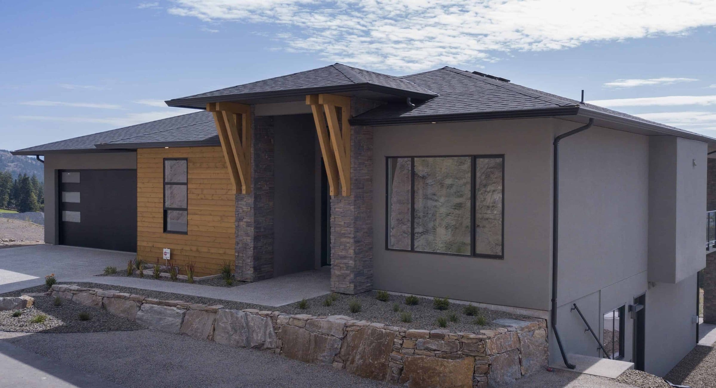 A finished home in Tallus Ridge, timber brackets over the entry and the hills behind