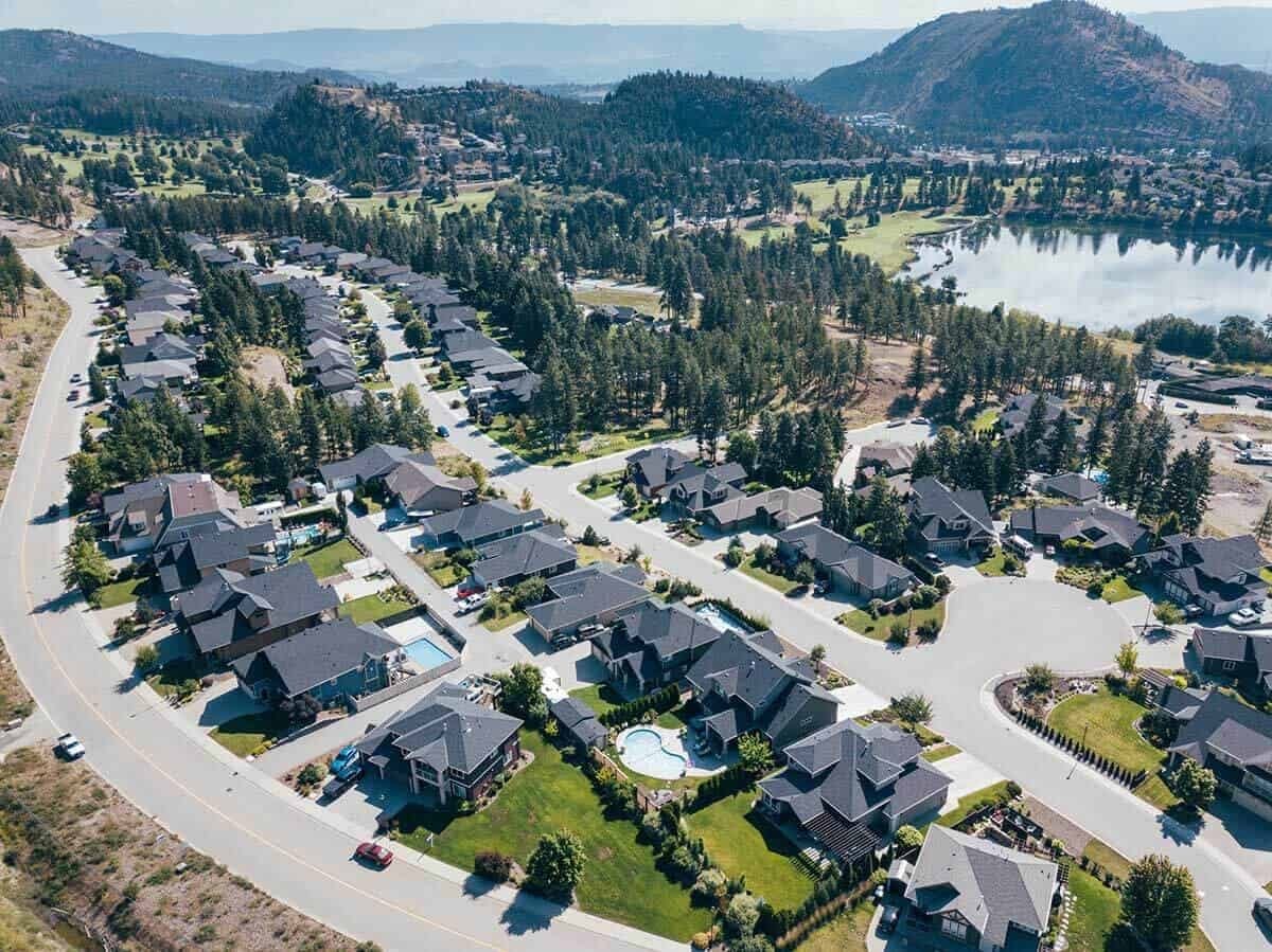 A home from the air, the pines behind it
